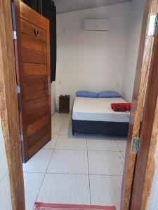 a small bedroom with a bed and a door at Pousada Aloha in Santos