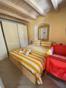 キアヴェンナにあるCasa Vacanze La Romanticaのベッドルーム(大型ストライプベッド1台、鏡付)