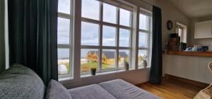 a living room with a couch and a large window at Fjøsen - Bleik Beach in Bleik