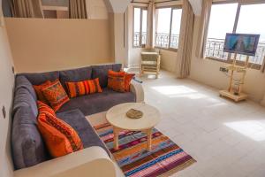 un soggiorno con divano e tavolo di SurfAppart Morocco a Tamraght Ouzdar