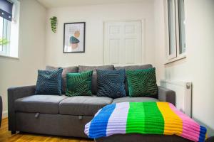 a living room with a couch with colorful pillows at Kent Tonbridge Townhouse in Kent