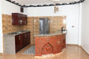 a kitchen with a brick fireplace in the middle at Jasmine Nile apartments in Luxor
