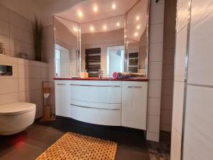 a bathroom with a sink and a toilet and a mirror at Ferienwohnung in 03159 Döbern 