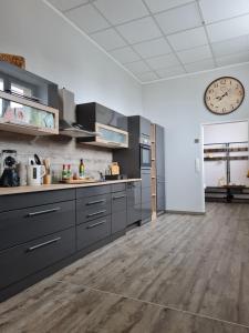 a kitchen with gray cabinets and a clock on the wall at Ferienwohnung in 03159 Döbern 