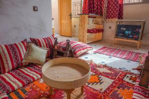 a living room with a couch and a tv at SurfAppart Morocco in Tamraght Ouzdar