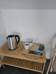 a table with a coffee pot and glasses on it at Tulipan in Krapkowice