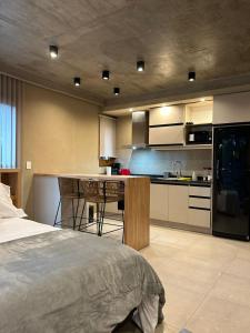 1 dormitorio con 1 cama y cocina con encimera en Maravilloso departamento con parrilla en Villa La Angostura