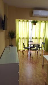 Una sala de estar con mesa y sillas y una cocina. en Sueña Paco, en Torremolinos
