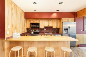 a kitchen with wooden cabinets and a counter with stools at Durant Unit D3, Condo with Floor-to-Ceiling Windows, Fireplace, and more in Aspen