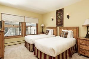 two beds in a hotel room with a window at Durant Unit D3, Condo with Floor-to-Ceiling Windows, Fireplace, and more in Aspen