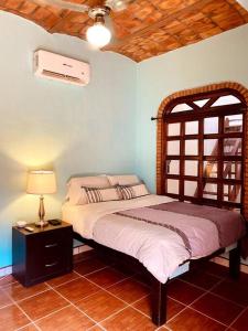a bedroom with a bed and a table with a lamp at Casa Jardin in Lo de Marcos