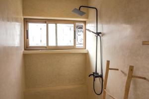 a shower in a bathroom with a window at SurfAppart Morocco in Tamraght Ouzdar