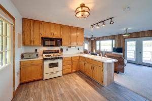 a kitchen with wooden cabinets and a stove top oven at Riverfront Fulton Vacation Rental with Deck and Grill! in Fulton