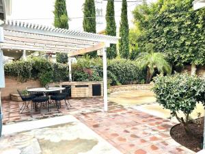 a patio with a table and chairs under a pergola at Spacious 4BR in Los Angeles in Los Angeles
