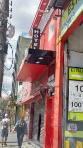 a man walking down a street in front of a store at Hotel Avenida Brás in Sao Paulo