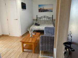 a small bedroom with a bed and a table at Apartamentos Algodonales in Algodonales