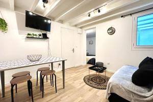 a living room with a table and some stools at Appartement douillet avec terrasse in Talence