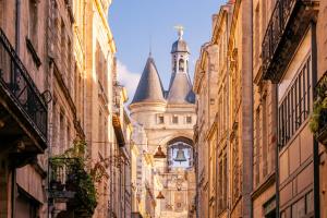 a building with a clock tower in the middle of a street at Appartement douillet avec terrasse in Talence