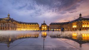 un grand bâtiment avec une fontaine devant lui dans l'établissement Appartement douillet avec terrasse, à Talence