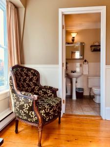 a bathroom with a chair and a sink at Le Chateau du Lac in Magog-Orford