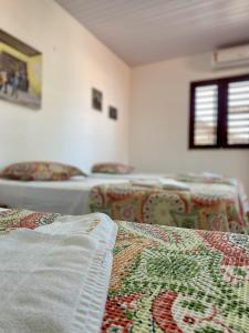 a room with a bed with a quilt on it at Pousada São Pedro in Flecheiras