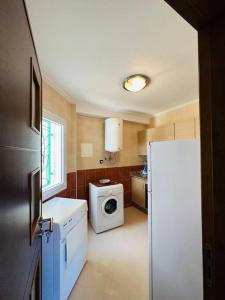 eine Küche mit einem Kühlschrank und einer Waschmaschine in der Unterkunft appartement de vacances achakar avec plage&piscine in Tangier