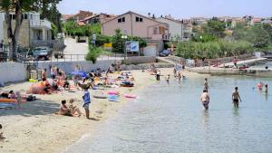Grupa ludzi na plaży w wodzie w obiekcie Apartment Silo 3 w mieście Šilo