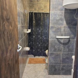 baño con ducha con cortina negra en Departamento Reconquista - Perla del Norte en Reconquista