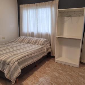 a bedroom with a bed and a window at Departamento Reconquista - Perla del Norte in Reconquista