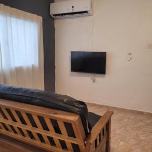 een woonkamer met een bank en een flatscreen-tv bij Departamento Reconquista - Perla del Norte in Reconquista