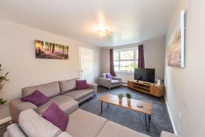 ein Wohnzimmer mit einem Sofa und einem TV in der Unterkunft Airport LPL - Driveway Parking - Garden in Widnes