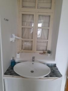 um lavatório branco numa casa de banho com uma janela em Alaçatı Frida Hotel em Cesme