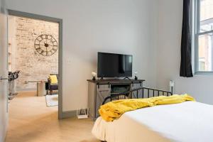 una camera con letto e TV su un tavolo di Gorgeous Condo in the Heart of DT Birmingham! a Birmingham