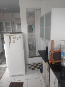 a kitchen with a white refrigerator and a toilet at Quitinete in Rio de Janeiro