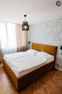 um quarto com uma cama grande e lençóis brancos em AH Považská III em Košice
