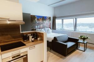 a room with a bed and a kitchen with a chair at 2L De Blend in Utrecht