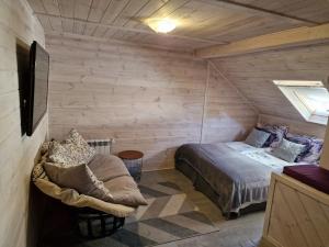 a bedroom with a bed and a chair in a room at Szczyrk Pokoje Gościnne Kacper Blisko Gondoli - Sauna in Szczyrk