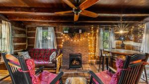 a living room with a couch and a fireplace at Smoky Speakeasy 2 Cabins 2 Hot Tubs and Private Pool in Gatlinburg