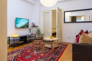 ein Wohnzimmer mit einem Sofa und einem Tisch in der Unterkunft Ultra-central University Square Apartament Apartament in Bukarest