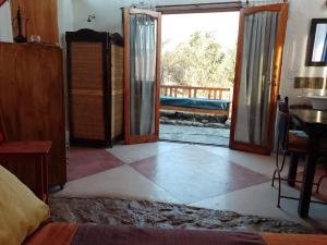 a bedroom with a door open to a patio at Refugio: El Llamado in Villa Las Rosas