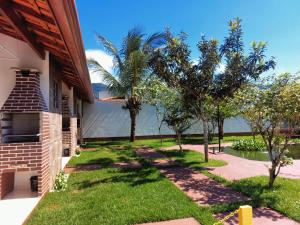 un patio con palmeras junto a una casa en Recanto Bela Vista en Peruíbe