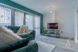 a living room with a couch and a tv at Luxury Birmingham City Centre Townhouse with BALCONY- Sleeps 10 - FREE Parking - Perfect for Contractors, Business Travellers, Families and other Groups - Near Bullring, Newstreet, Selfridges, NEC, NIA & Birmingham airport in Birmingham