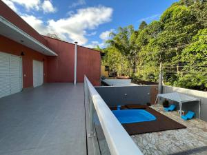 un balcón de una casa con piscina en Casa charmosa com piscina em rua tranquila en São Sebastião