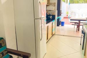 - une cuisine équipée d'un réfrigérateur au milieu d'une pièce dans l'établissement Casa charmosa com piscina em rua tranquila, à São Sebastião