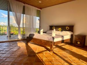 a bedroom with a bed and a large window at Casa Campestre Denis in Guamal