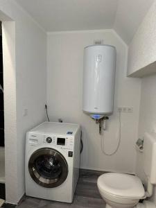 a bathroom with a washing machine and a toilet at PrimeBnb Bad Salzungen in Bad Salzungen
