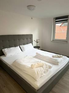 1 cama blanca grande en un dormitorio con ventana en PrimeBnb Bad Salzungen en Bad Salzungen
