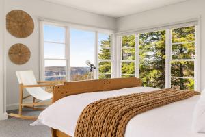 a bedroom with a bed and a desk and windows at Blue Mountains Bliss in Leura