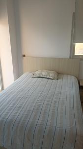 uma cama num quarto com um lençol listrado em Arriendo Apartamento Amoblado En Puerto Colombia Villa Campestre em Barranquilla