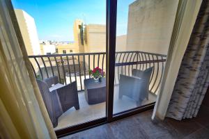 a balcony with chairs and a potted plant on it at 49 Sunrise Lodge in Għajnsielem